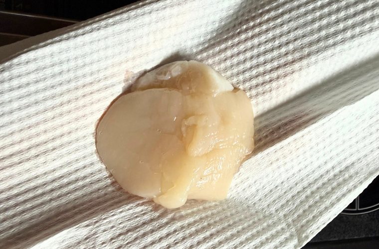 ほたての水分をキッチンペーパーで取っている