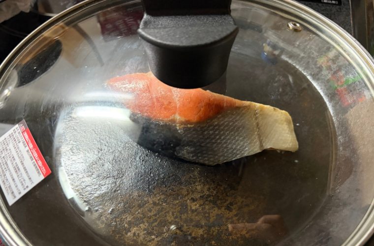 フライパンに蓋をして鮭を蒸焼き